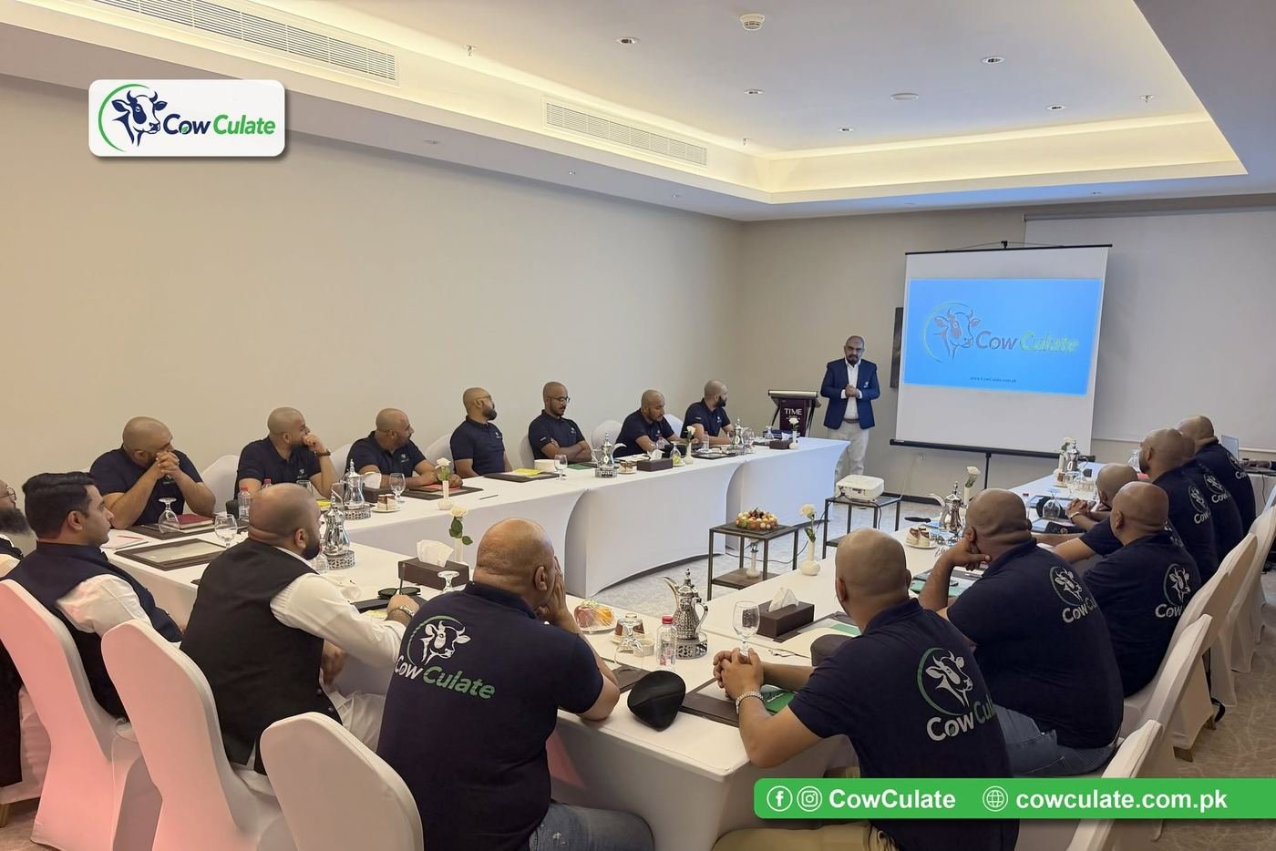 CowCulate team members in branded attire listening to the launch presentation